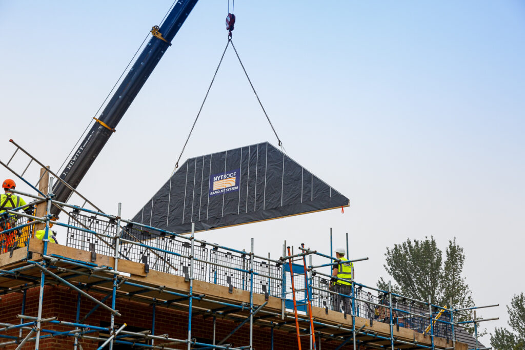 A spandrel panel being lowered into place ready to construct the NYTROOF, which is a panelised room in the roof system